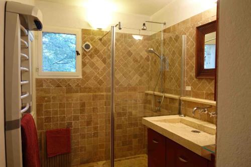 La salle de bains est pourvue d'une douche et d'un lavabo. dans l'établissement L'Enclos, à Aix-en-Provence