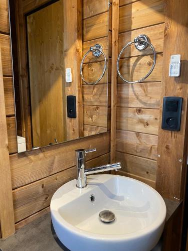 une salle de bain avec un lavabo blanc et un miroir dans l'établissement Chalet du Bassin Arcachon - Camping Parc aquatique, à Gujan-Mestras