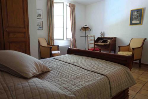 a bedroom with a bed and chairs and a desk at L'Enclos in Aix-en-Provence