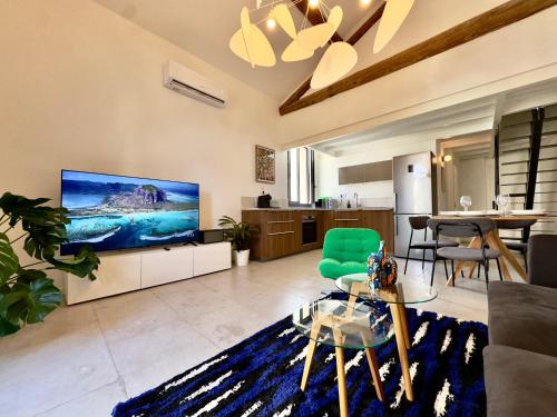 un salon avec une grande télévision à écran plat dans l'établissement LOFT - 10 min du centre ville - Terrasse - Parking, à Montpellier