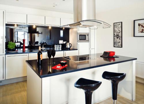 a kitchen with a counter with stools in it at Reading Modern Two Bedroom Apartment in Reading