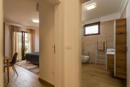 een slaapkamer met een bed en een badkamer met een bad bij Villa Lo La by Istrialux in Svetvinčenat