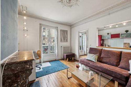 un salon avec un canapé et une table dans l'établissement Le Marceau - Wifi Courbevoie, à Courbevoie