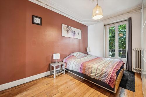 une chambre avec un lit et une table avec une lampe dans l'établissement Le Marceau - Wifi Courbevoie, à Courbevoie