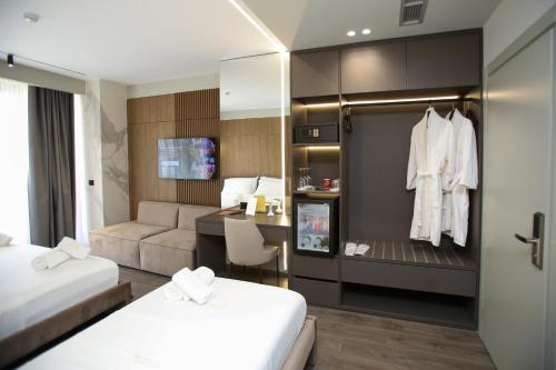 a hotel room with two beds and a desk at Charm Hotel in Vlorë