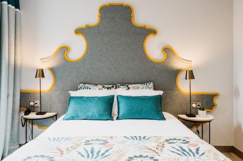 una camera da letto con un letto grande con cuscini blu di Auberge De Saint-Rémy - Restaurant Gastronomique a Saint-Rémy-de-Provence