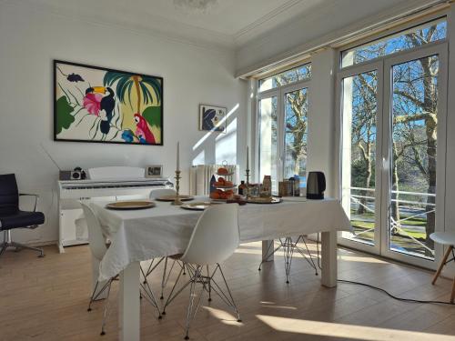 a white dining room with a table and chairs at Résidence Souverain 94 in Brussels