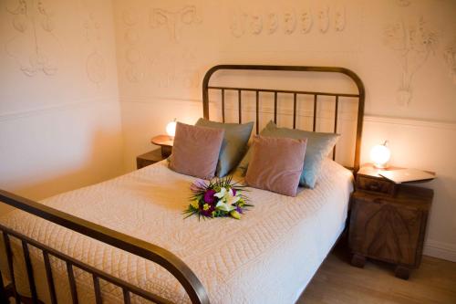 a bedroom with a bed with a flower arrangement on it at Surprenantes - Château du Pé in Saint-Jean-de-Boiseau