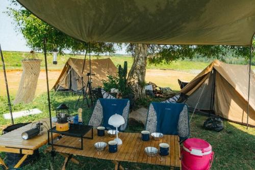 a tent with chairs and a table in front of some tents at Goin Out Camping Tam Kỳ in Phường Hòa (1)