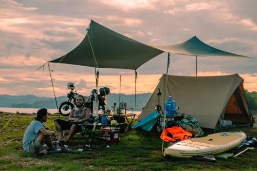 two men are sitting in front of a tent at Goin Out Camping Tam Kỳ in Phường Hòa (1)
