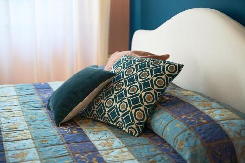 a bed with four pillows on top of it at Hotel Belvedere Ranco in Ranco