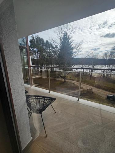 a view of a balcony with a table and a large window at Apartament Perła A20 nad jeziorem Pluszne in Olsztynek