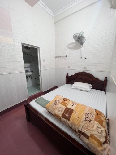 a bedroom with a bed and a fan and a mirror at Nhà nghỉ Phương Lệ in Tiên Tân