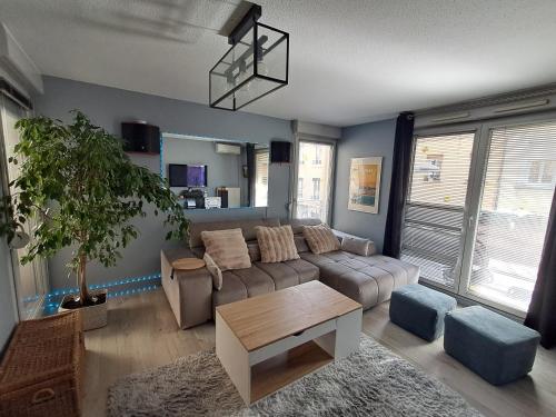 un salon avec un canapé et une table dans l'établissement Appartement T3 climatisé Lyon Caluire et Cuire, à Caluire-et-Cuire