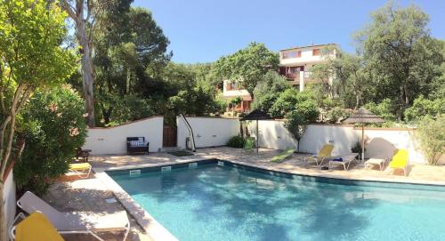 une piscine avec des chaises et un bâtiment dans l'établissement Le Panorama, à Argelès-sur-Mer