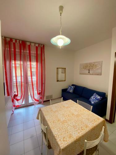 a living room with a table and a blue couch at Cardinali House in Cattolica