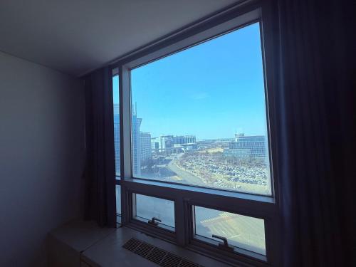 a window in a room with a view of a city at Incheon Airport Stay Guesthouse in Incheon
