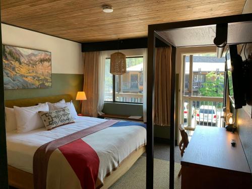 a bedroom with a large bed and a balcony at Station House Inn South Lake Tahoe in South Lake Tahoe