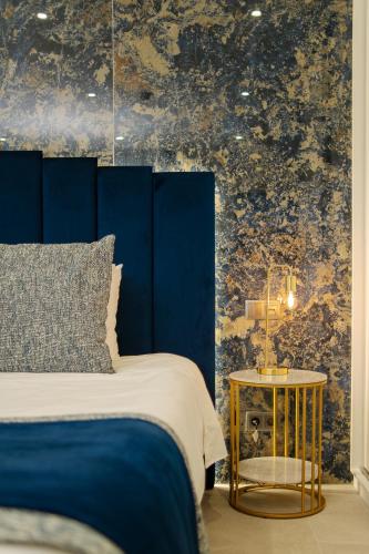 a bedroom with a blue bed and a side table at Safira Suites 101 in Funchal