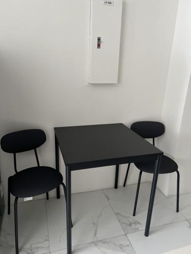 a black table and two chairs in a room at The Bauhouse Studio with Balcony near Eastwood in Manila