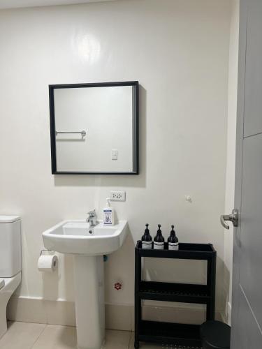 a bathroom with a sink and a mirror on the wall at The Bauhouse Studio with Balcony near Eastwood in Manila