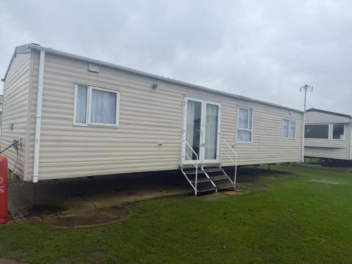 a mobile home is parked in a yard at 6 Bed Static Carvan Seawick Holiday Park in Saint Osyth