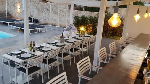 a dining room with a table and chairs and a pool at Galini Breeze in Agia Galini