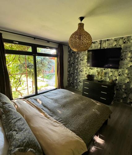 ein Schlafzimmer mit einem großen Bett und einem Fenster in der Unterkunft O Casǎ in 23 August