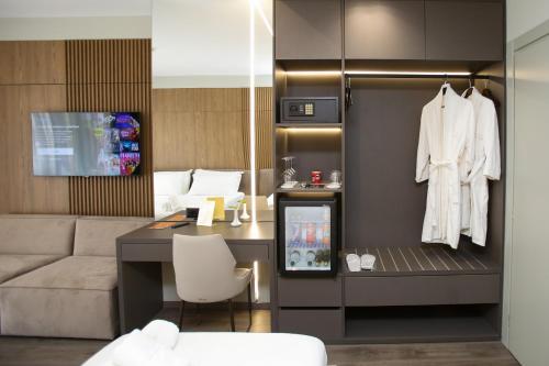 a room with a couch and a table with a white robe at Charm Hotel in Vlorë