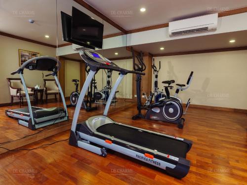 a gym with two exercise bikes and a flat screen tv at Decharme Hotel in Chiang Mai