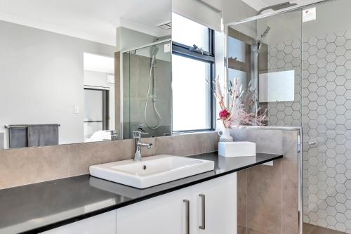 a bathroom with a sink and a mirror at Oceanfront Retreat With Stunning Marina Views in Mandurah
