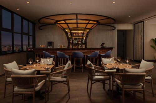 a restaurant with tables and chairs and a bar at Courtyard by Marriott Casablanca Downtown in Casablanca