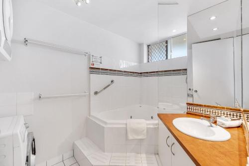 a white bathroom with a tub and a sink at Headlands 10 Two Bedroom Beachside Apartment with Magical Ocean Views Great Value for Money in Alexandra Headland