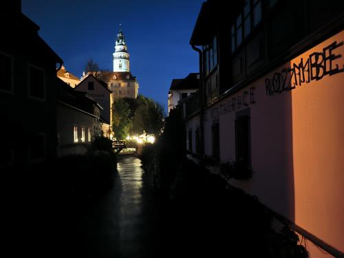 a city at night with a clock tower in the background at Pokojíky na Větrné in Malšín