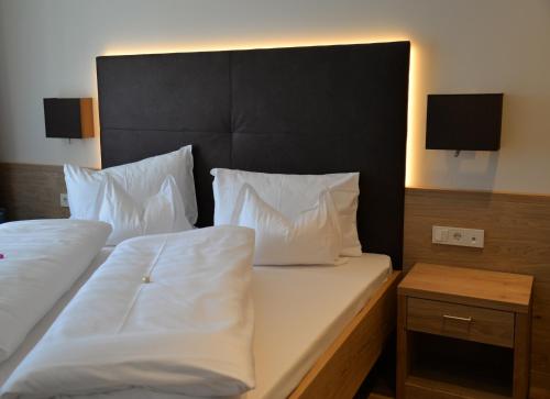a hotel room with two beds with white pillows at Panorama Residence Öhlerhof in Lagundo