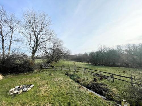 WhitlandにあるThe Longhouse at Pencwm Escapesの塀と小川の畑