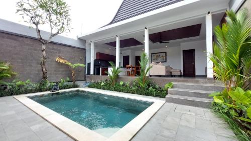a swimming pool in front of a house at Chic 2BR Cozy & Private Pool at Bareng Villa in Ubud