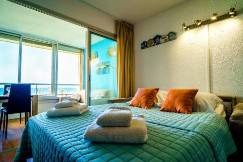 une chambre avec un lit avec des oreillers dessus dans l'établissement Les pieds dans le sable, au Barcarès