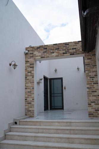 a staircase leading to a white building with a black door at קאסה לונה בוטיק CASA LUNA boutique in Gan Yavneh