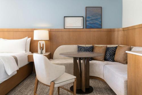 a room with a bed and a couch and a table at Moana Surfrider, A Westin Resort & Spa, Waikiki Beach in Honolulu