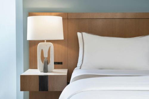 a hotel room with a bed and a phone on a night stand at Moana Surfrider, A Westin Resort & Spa, Waikiki Beach in Honolulu
