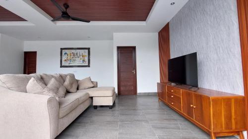a living room with a couch and a flat screen tv at Chic 2BR Cozy & Private Pool at Bareng Villa in Ubud