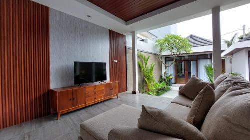 a living room with a couch and a flat screen tv at Chic 2BR Cozy & Private Pool at Bareng Villa in Ubud