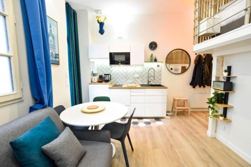 un salon avec une table et une cuisine dans l'établissement Hyper-Centre Studio Lekain UnSejourANantes, à Nantes