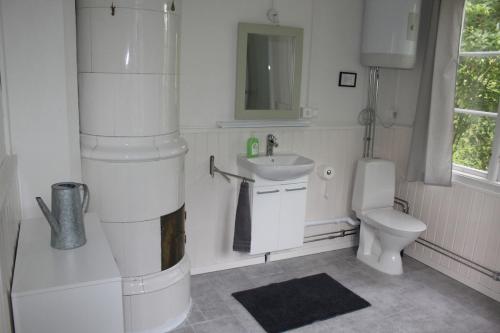 a white bathroom with a sink and a toilet at Villa Lilly, near Vimmerby in Vimmerby