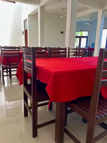 a dining room with a red table and chairs at Kamatha Hotel & Restaurant in Ambalantota
