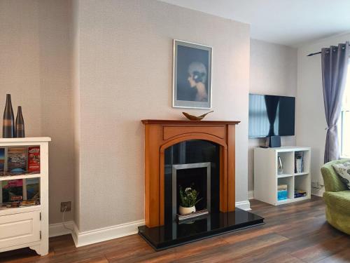 a living room with a fireplace with a picture on the wall at Relaxing retreat in Lisburn in Lisburn