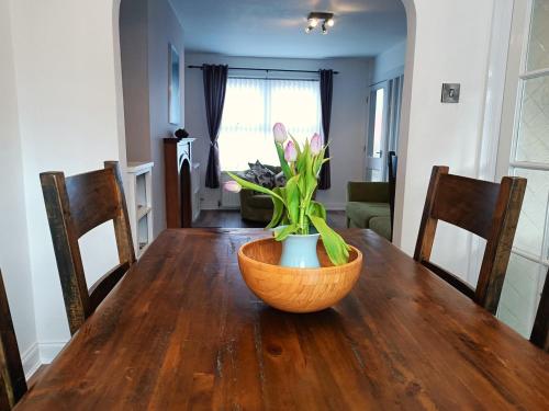 a wooden table with a vase of flowers on it at Relaxing retreat in Lisburn in Lisburn