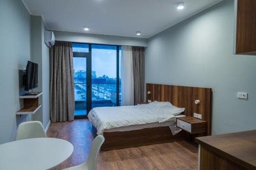 a hotel room with a bed and a large window at Sunny Spot Batumi in Batumi