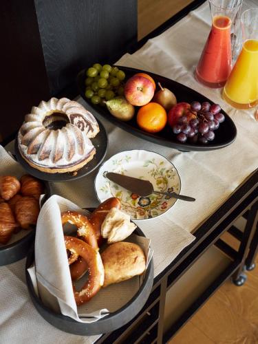 a table topped with plates of bread and fruit at Chiemgauhof Lakeside Retreat in Übersee